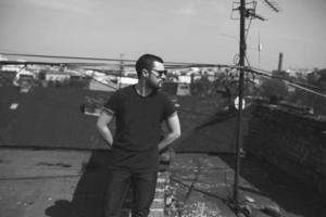 The man in the authentic boots and jeans selvedge on the roof of the building in the old town photo