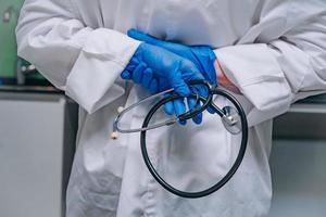 doctor in a white robe holding a phonendoscope photo