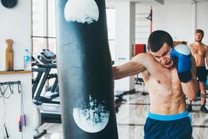 boxeador con saco de boxeo en el gimnasio foto