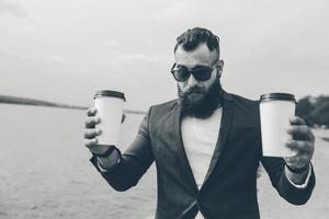 well-dressed man carries coffee photo