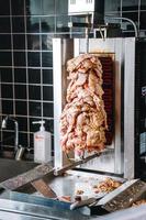 Doner kebab on rotating vertical spit. Street food, fast food concep photo