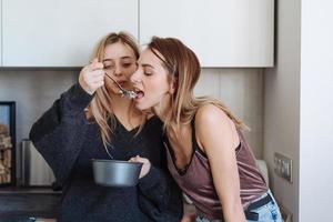 two girls eat porridge at home photo