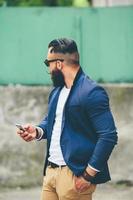 Bearded businessman looking at phone photo