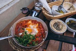 Shakshuka, Fried Eggs in Tomato Sauce on the Table photo