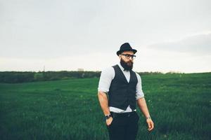 A man with a beard and sunglasses walking on the field photo