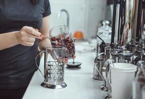 Pour dry tea leaves into the glass container of the tea press maker photo