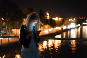 Girl with a smartphone on a bridge photo