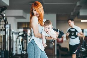 joven madre con su hijo pequeño en el gimnasio foto