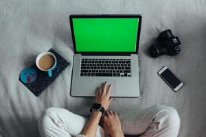 mujer usando laptop en su cama foto