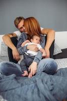 Happy family with newborn baby on the bed photo