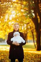 papá e hijo recién nacido en el parque de otoño foto