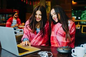 two girls watching something in laptop photo