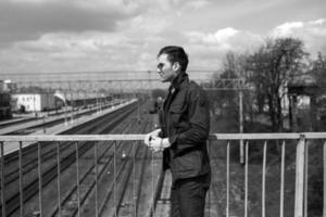 A man dressed in jeans on the background of the train and the station photo