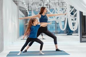 madre adulta joven y pequeña hija juntas en aeróbicos foto