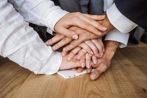 United hands of business team on workspace background photo