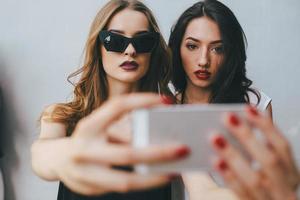 Two girlfriends taking a selfie photo