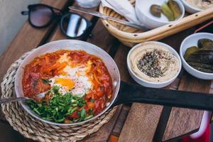 Shakshuka, Fried Eggs in Tomato Sauce on the Table photo