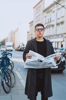 Smart man in sunglasses with paper on street photo