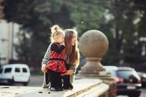 Mother and little daughter playing in a park photo