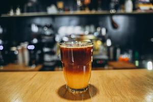 Glass with cold coffee and ice and orange. photo