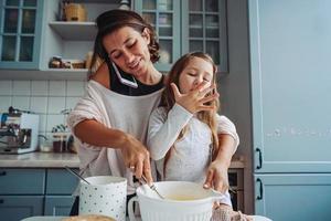 mamá le enseña a su pequeña hija a cocinar foto