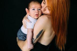 joven madre mujer sosteniendo a su hijo bebé foto