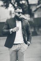 hombre con barba fuma cigarrillo electrónico foto