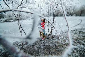 beautiful couple posing near a frozen river photo