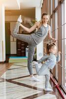 Mom and daughter together perform different exercises photo