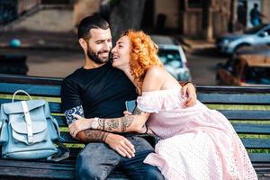 Beautiful dating couple hugging on a bench photo