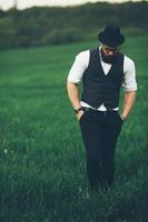 A man with a beard and sunglasses walking on the field photo