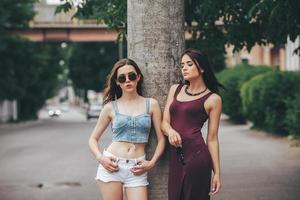 Two beautiful young girls posing in the city photo