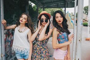 Three beautiful young girls at the bus stop photo