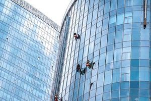 trabajadores lavando ventanas en el edificio de oficinas foto