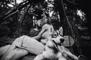 beautiful couple together with dog on a swing photo