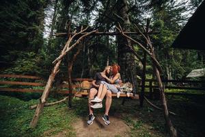 beautiful couple together with dog on a swing photo