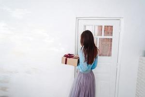 mujer sosteniendo una caja de regalo de navidad en sus manos foto