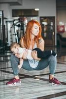 joven madre con su hijo pequeño en el gimnasio foto