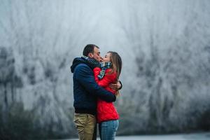 beautiful couple posing near a frozen river photo