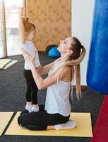 Mom and daughter together perform different exercises photo