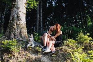 beautiful couple sitting in a forest near the tree photo