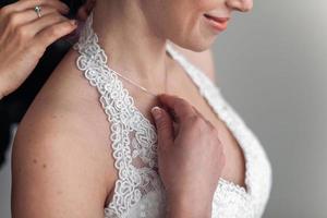 maid of honor helping the bride with her dress photo