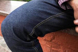 cuerpo inferior de hombres vestidos con jeans de orillo, zapatos retro y camisa a cuadros. foto