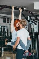 chico besa a la novia en el entrenamiento en el gimnasio foto