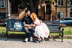 Beautiful dating couple hugging on a bench photo