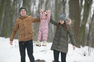 Dad and Mom with a little daughter in the park photo