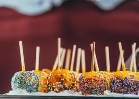 Apples in caramel and sprinkles. Street food. photo