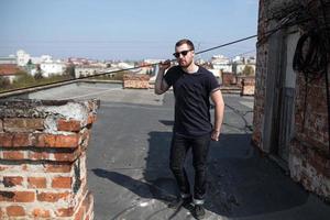 The man in the authentic boots and jeans selvedge on the roof of the building in the old town photo