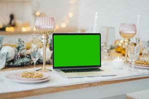 portátil con pantalla verde - cromakey cerca de las decoraciones de año nuevo. tema de navidad foto