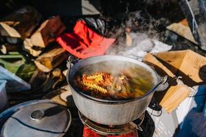 sopa hirviendo en el quemador, cocinando comida al aire libre con chorro de gas foto